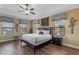 Comfortable main bedroom with a ceiling fan, wood floors and lots of natural light at 1164 Castle Pines Ct, Reunion, FL 34747