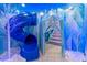 Imaginative Frozen-themed playroom with slide, ice castle entrance, and winter wonderland decor at 1164 Castle Pines Ct, Reunion, FL 34747
