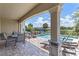 Outdoor space with covered patio including a dining set and lounge chairs adjacent to the inviting swimming pool at 1164 Castle Pines Ct, Reunion, FL 34747