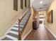 Elegant staircase showcasing wood railing with decorative iron spindles, leading to the upper level of the home at 1164 Castle Pines Ct, Reunion, FL 34747
