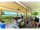 Relaxing back porch with a scenic lake view, equipped with a grill and seating area at 130 Masterpiece Rd, Lake Wales, FL 33898