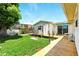 Charming backyard with a wooden deck, lush greenery, and a view of the house at 130 Masterpiece Rd, Lake Wales, FL 33898