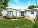 Exterior of home featuring a ramp, deck, and grassy area for outdoor enjoyment at 130 Masterpiece Rd, Lake Wales, FL 33898