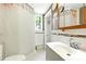 Well-lit bathroom featuring white tile, a shower with curtain, and a large mirror at 130 Masterpiece Rd, Lake Wales, FL 33898