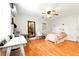 Bright bedroom featuring wood floors, ceiling fan, and a mirror reflecting the kitchen at 130 Masterpiece Rd, Lake Wales, FL 33898