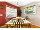 Dining room with red accent wall, wood floors, decorative chairs, and views of exterior at 130 Masterpiece Rd, Lake Wales, FL 33898