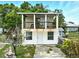 Charming two-story home with front porch and exterior staircase surrounded by greenery at 130 Masterpiece Rd, Lake Wales, FL 33898