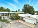 Waterfront home with a detached garage and covered parking area with mature landscaping and view of lake at 130 Masterpiece Rd, Lake Wales, FL 33898