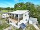 Two-story home with wood porch, outdoor solar panel, and shed, set against a blue sky at 130 Masterpiece Rd, Lake Wales, FL 33898