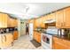 Kitchen with tile flooring, wood cabinets, and white appliances at 130 Masterpiece Rd, Lake Wales, FL 33898