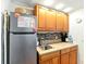 Efficient kitchenette featuring wood cabinets, stainless steel fridge, and tiled backsplash at 130 Masterpiece Rd, Lake Wales, FL 33898