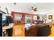 Spacious living room with hardwood floors, a ceiling fan, and large windows providing ample natural light and an outdoor view at 130 Masterpiece Rd, Lake Wales, FL 33898