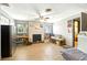 Open living room with a brick fireplace, ceiling fan, and wood-look flooring at 130 Masterpiece Rd, Lake Wales, FL 33898