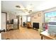 Cozy living room featuring a brick fireplace, ceiling fan and wood flooring at 130 Masterpiece Rd, Lake Wales, FL 33898