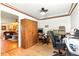 A functional office space has hardwood floors, a ceiling fan, closet space, and provides a view of the kitchen and living area at 130 Masterpiece Rd, Lake Wales, FL 33898