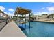 A covered boat lift and dock sit on a canal with waterfront residences at 139 Douglas St, Edgewater, FL 32141