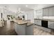 Open concept kitchen features stone countertops, modern appliances, and seamless transition to the living area at 139 Douglas St, Edgewater, FL 32141