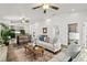 Bright living room with white sofas, wood floors, ceiling fans, and an open floor plan is great for entertaining at 139 Douglas St, Edgewater, FL 32141