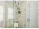 Walk-in shower featuring glass enclosure, marble tile, shower seat, and modern fixtures at 139 Douglas St, Edgewater, FL 32141