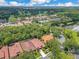 Scenic aerial view of the neighborhood featuring tile roofs, mature trees, and a serene lake in a vibrant community at 1609 Glen Eagles Way, Orlando, FL 32804