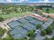 An aerial view of a tennis court, surrounded by a lush golf course landscape with community amenities at 1609 Glen Eagles Way, Orlando, FL 32804