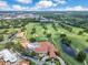 Aerial view showcasing the community clubhouse, golf course, pond and lush landscaping in a beautiful neighborhood at 1609 Glen Eagles Way, Orlando, FL 32804