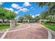 Attractive gated entrance to the community with brick pavers and professional landscaping under a sunny sky at 1609 Glen Eagles Way, Orlando, FL 32804