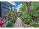 Stone path winding through a serene garden with mature plants and a pergola in this calming outdoor space at 1609 Glen Eagles Way, Orlando, FL 32804