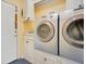 This laundry room features a side-by-side washer and dryer with white cabinets and neutral walls at 1609 Glen Eagles Way, Orlando, FL 32804