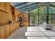 Bright sunroom with floor-to-ceiling windows, wood cabinets, and comfortable seating at 1609 Glen Eagles Way, Orlando, FL 32804