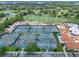 An overhead view showing tennis courts and a putting green surrounded by a picturesque, green landscape at 1609 Glen Eagles Way, Orlando, FL 32804