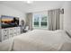 Comfortable bedroom with a large TV, plush decor, and bright windows at 17426 Saw Palmetto Ave, Clermont, FL 34714