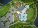 Aerial view of the community clubhouse with a pool, playground, parking lot, and greenery at 17426 Saw Palmetto Ave, Clermont, FL 34714