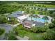 Aerial view of the community clubhouse and pool area surrounded by lush landscaping and a lake at 17426 Saw Palmetto Ave, Clermont, FL 34714