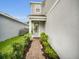 Inviting front entrance with a brick pathway, lush landscaping, and a stylish front door at 17426 Saw Palmetto Ave, Clermont, FL 34714