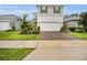 Attractive two-story home showcasing a two-car garage and well-maintained landscaping with a brick-paved driveway at 17426 Saw Palmetto Ave, Clermont, FL 34714