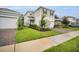 Well-kept two-story home featuring a two-car garage and a spacious front yard with lush green grass at 17426 Saw Palmetto Ave, Clermont, FL 34714