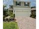Charming two-story home featuring a two-car garage and a well-manicured front yard with brick-paved driveway at 17426 Saw Palmetto Ave, Clermont, FL 34714