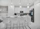 Well-lit kitchen featuring white cabinets, stainless steel appliances, island with seating and pendant lights at 17426 Saw Palmetto Ave, Clermont, FL 34714