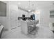 Modern kitchen with white cabinets, stainless steel appliances, and an island with bar stool seating at 17426 Saw Palmetto Ave, Clermont, FL 34714