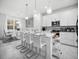 Open concept kitchen with island bar, pendant lighting, white cabinets, and dining area visible at 17426 Saw Palmetto Ave, Clermont, FL 34714