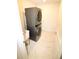 Modern laundry room with stacked washer and dryer, with sleek white tile flooring at 17426 Saw Palmetto Ave, Clermont, FL 34714