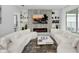 Bright living room featuring modern fireplace, large TV, stylish decor and plush white sofas at 17426 Saw Palmetto Ave, Clermont, FL 34714