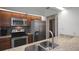 Modern kitchen featuring granite countertops, stainless steel appliances, and dark wood cabinets at 199 Heron Bay Cir, Lake Mary, FL 32746