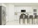 Modern kitchen featuring white cabinetry, stainless steel appliances, and a breakfast bar with seating at 2125 Lasso Loop, Eagle Lake, FL 33839