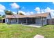Exterior view of the house highlighting the screened patio and spacious, well-manicured backyard at 2375 Belen Dr, Deltona, FL 32738