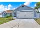 Attached two-car garage of single story home, complemented by lush landscaping at 2375 Belen Dr, Deltona, FL 32738