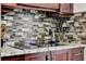 A view of the kitchen with mosaic tile backsplash, modern appliances and granite countertops at 2375 Belen Dr, Deltona, FL 32738