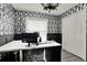 Home office with decorative wallpaper, large desk and a closet with folding doors at 2375 Belen Dr, Deltona, FL 32738