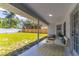 Covered back patio with comfortable seating overlooking a spacious, well-maintained backyard and fence line at 2444 Omaha Dr, Deltona, FL 32738